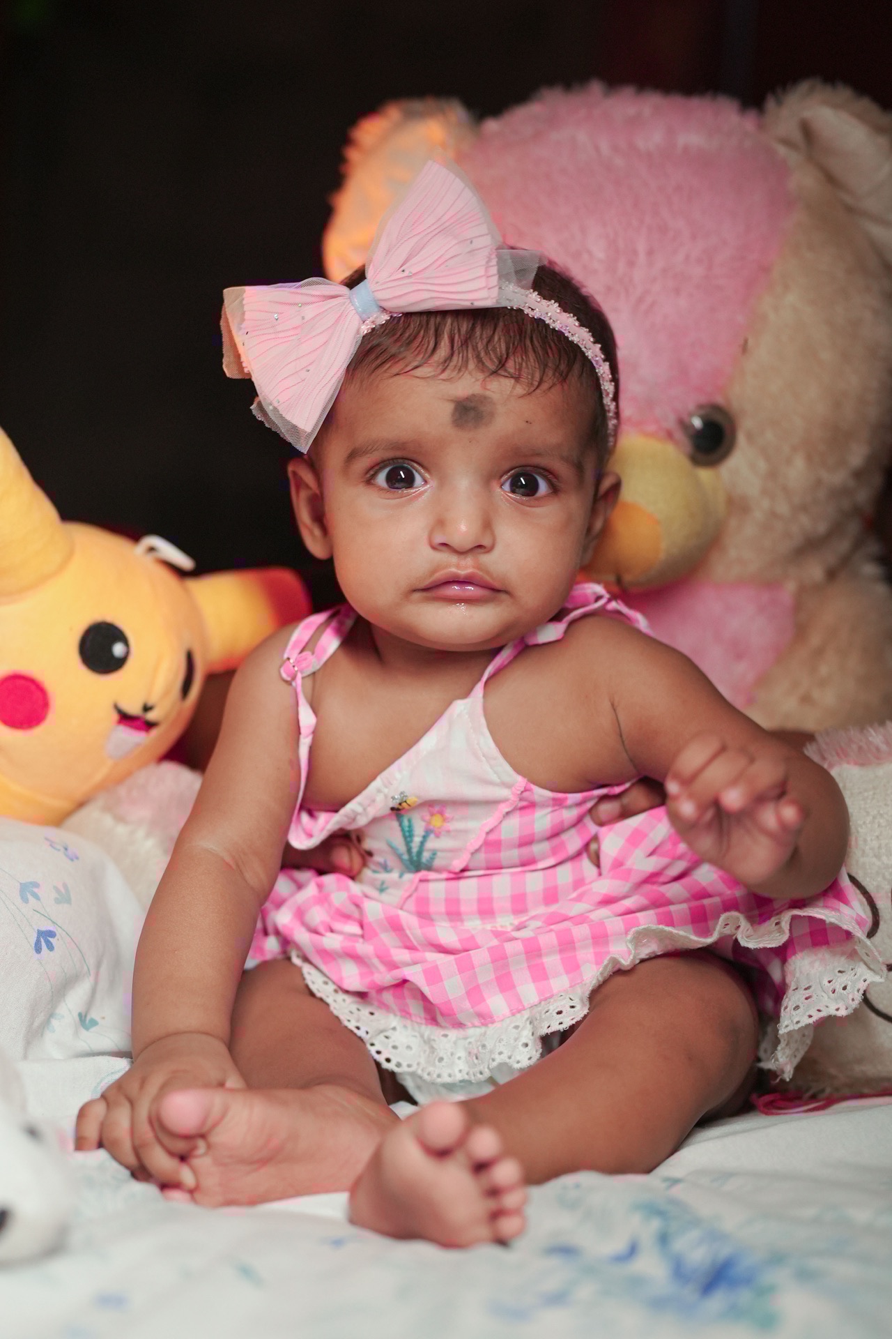 Sweet baby portrait surrounded by cuddly plush toys
