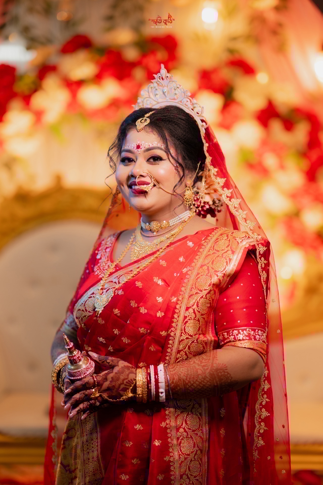 Smiling bride Debopriya holding auspicious Gachhkouto