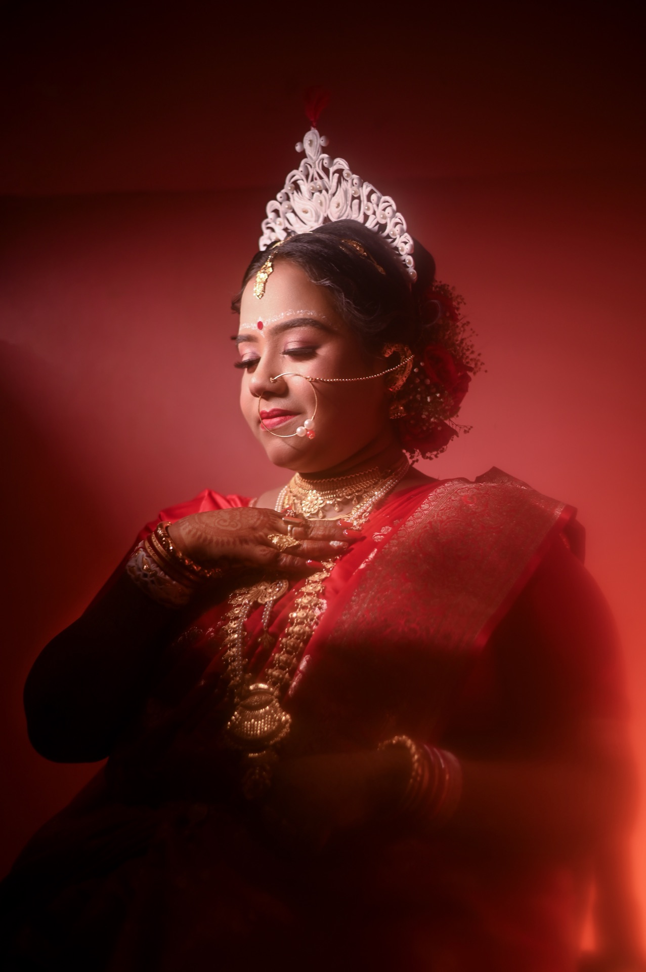 Regal Bengali Bride with Mukut in warm crimson lighting